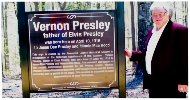 Mackey with sign at Vernon's birthplace